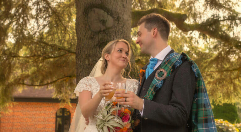 Bride and groom toast in the grounds of Careys Manor Hotel wedding venue