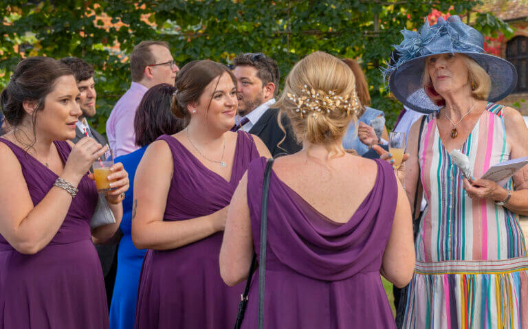 Bridesmaids and wedding guests enjoying drinks on the lawn at Careys Manor Hotel wedding venue