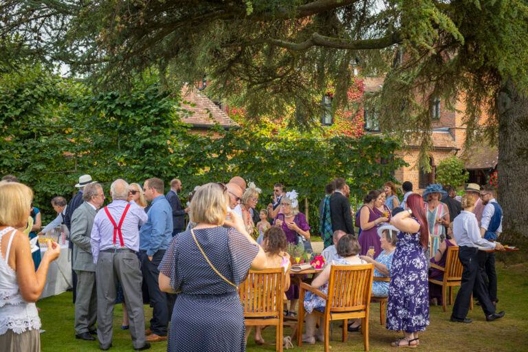 Wedding guests enjoy drinks on the lawn at Careys Manor Hotel wedding venue