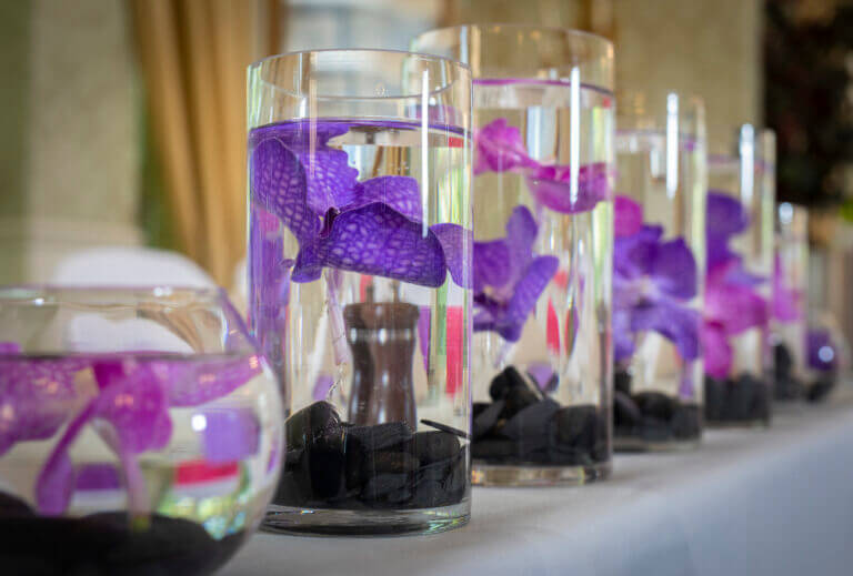 Vases filled with purple flowers on shelf in wedding display at Careys Manor Hotel