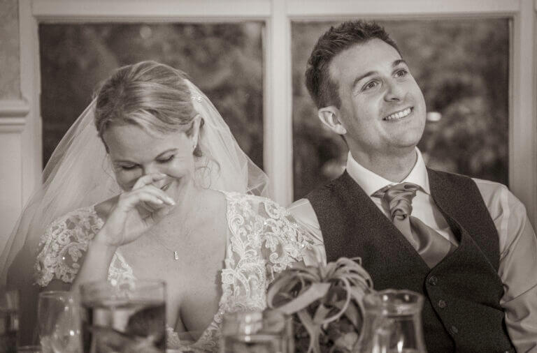 Black and white photo of bride and groom at the head table