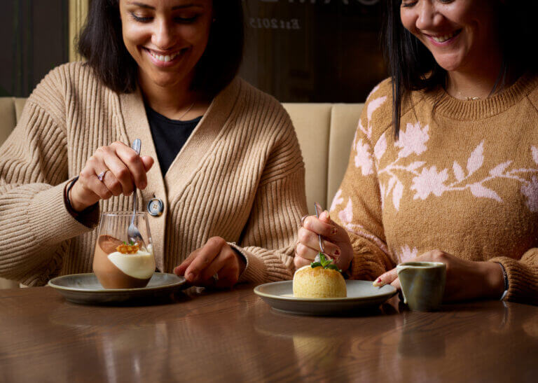 Two women enjoy desserts at Cambium restaurant in Brockenhurst - chocolate mousse and sponge pudding 