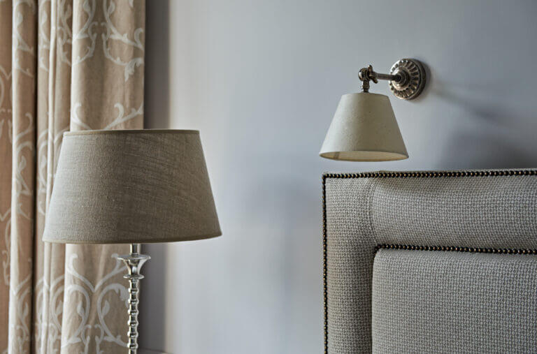 Detail shot of headboard and lampshades in room at Careys Manor hotel