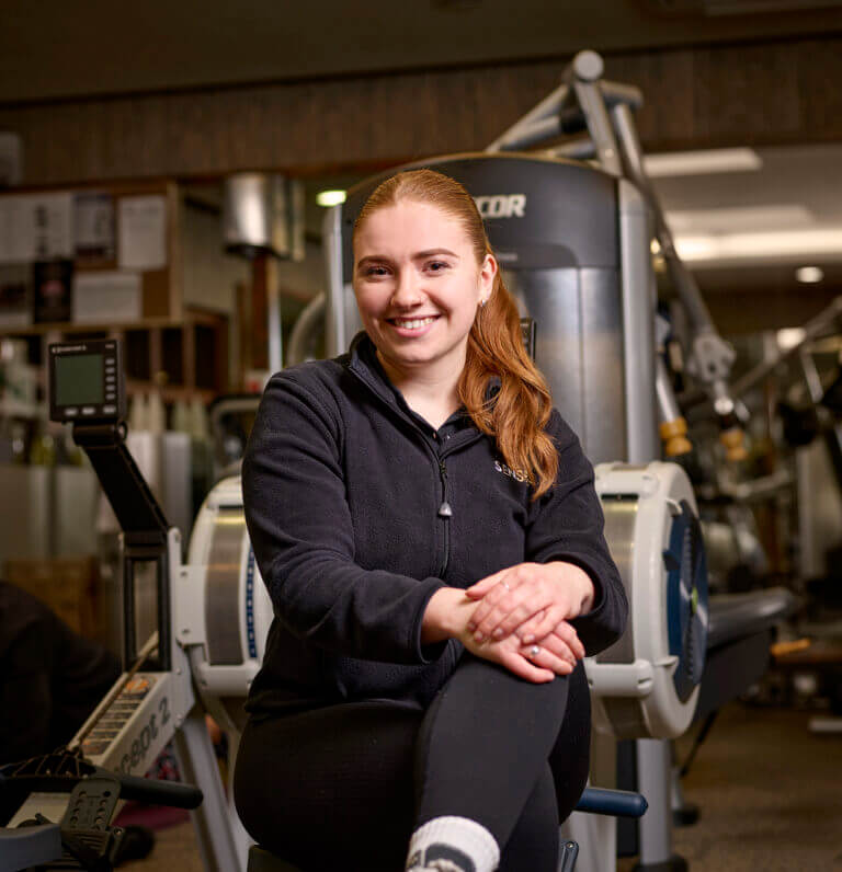 SenSpa Personal Trainer Jess smiles on rowing machine in gym