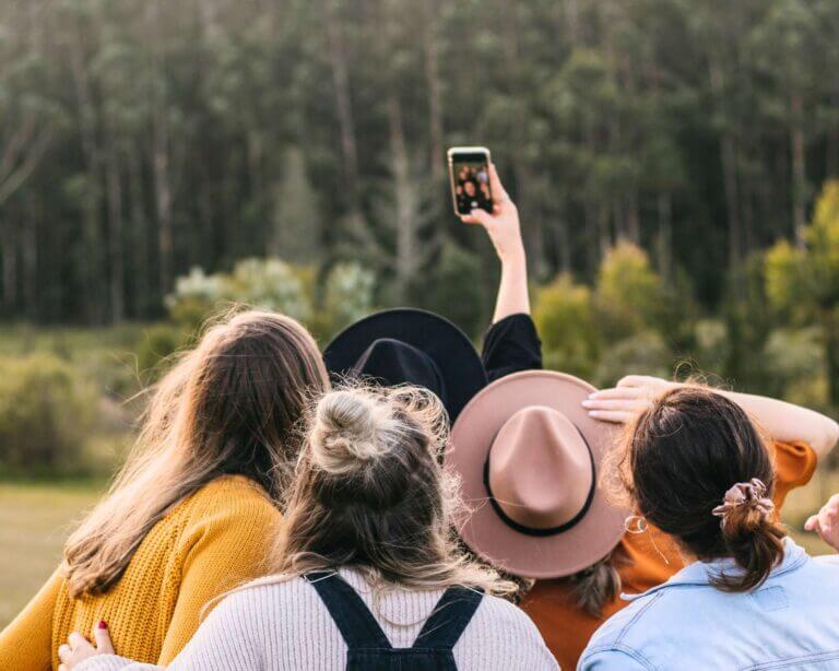 Group of female friends in the forest taking a group selfie