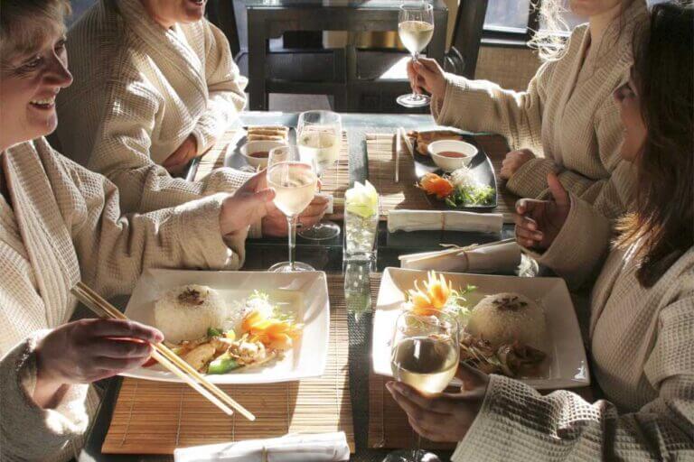 Group of four ladies enjoying Thai lunch on their spa day in their robes at Zen Garden restaurant in Careys Manor Hotel & SenSpa