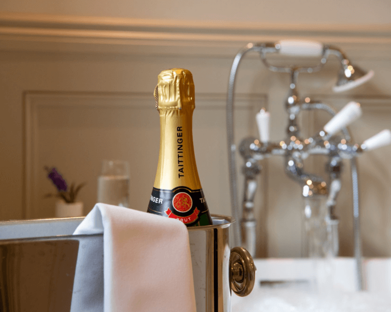 Champagne and a freestanding bath tub at Careys Manor Hotel