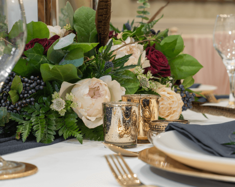 Table is set for a wedding breakfast with floral arrangement centrepiece